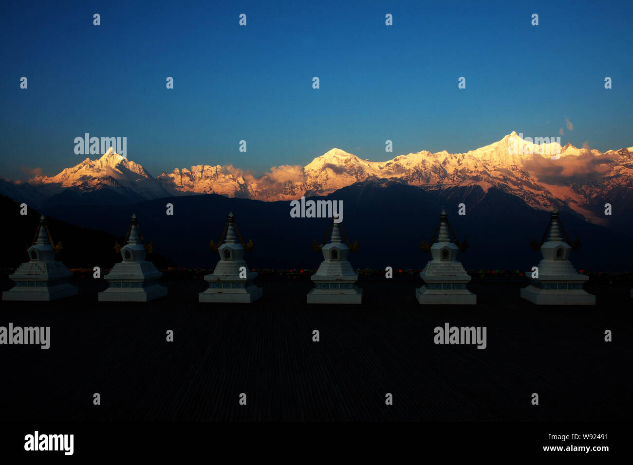 Stupa tibetano sono illuminato dal glorioso sunrise nel Kawagebo picco a Meili Snow Mountain in Deqin county, porcellane nordest della provincia dello Yunnan, 3 Foto Stock