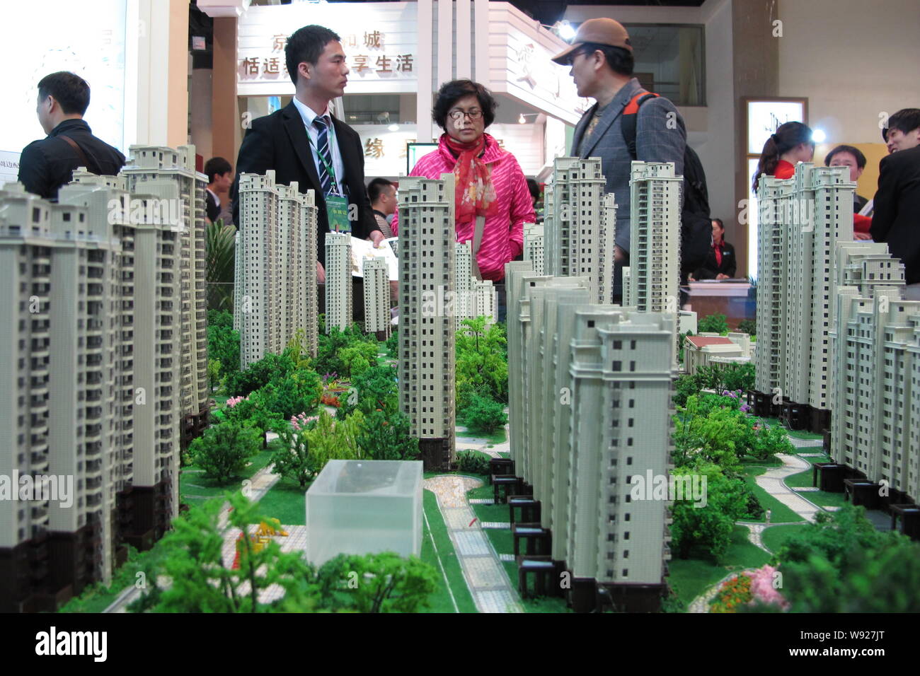 --FILE--cinese i homebuyers parla con un rappresentante nella parte anteriore dell'alloggiamento modelli durante una fiera immobiliare a Pechino in Cina, 12 aprile 2013. Controllare h Foto Stock