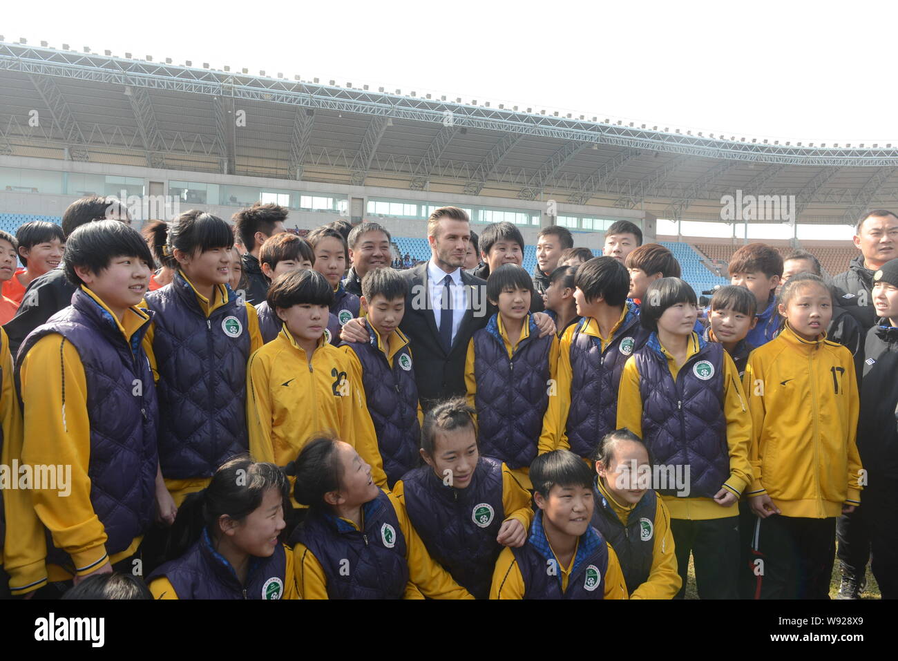 Inglese soccer superstar David Beckham, centro, pone con giovani calciatori cinesi durante la sua visita alla Tiantai Centro sportivo a Qingdao City, ea Foto Stock