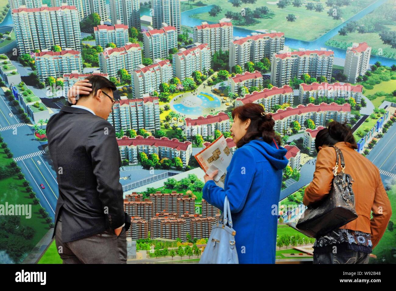 --FILE--cinese i homebuyers visualizza i modelli di alloggiamento durante una fiera immobiliare in Cina a Shanghai, 15 marzo 2013. Controllare home aumenti di prezzo in mento Foto Stock