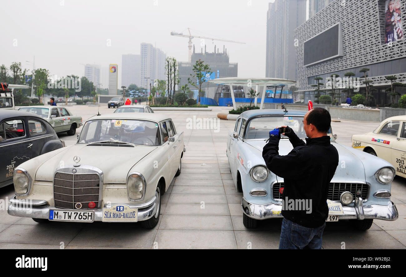 Un visitatore cinese prende le foto di un vecchio timer auto della casa di Stoccarda che ha compiuto 2013 Silk Road Rallye durante una mostra al negozio Quanshun Foto Stock