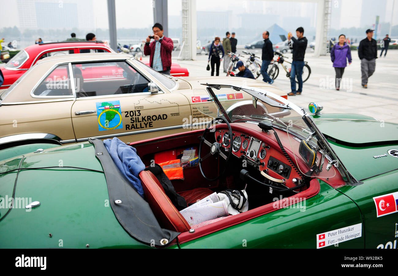 Visitatori guardare old timer auto di Mg e di altri marchi che hanno realizzato 2013 Silk Road Rallye durante una mostra a Quanshun shopping plaza ho Foto Stock