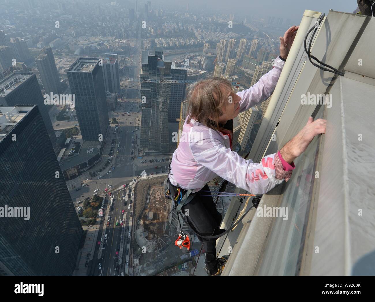 Il francese Spiderman Alain Robert è scalare il 288-metro-alto orizzonte Shimao edificio centrale nella città di Shaoxing, est Chinas nella provincia di Zhejiang, 21 Decemb Foto Stock