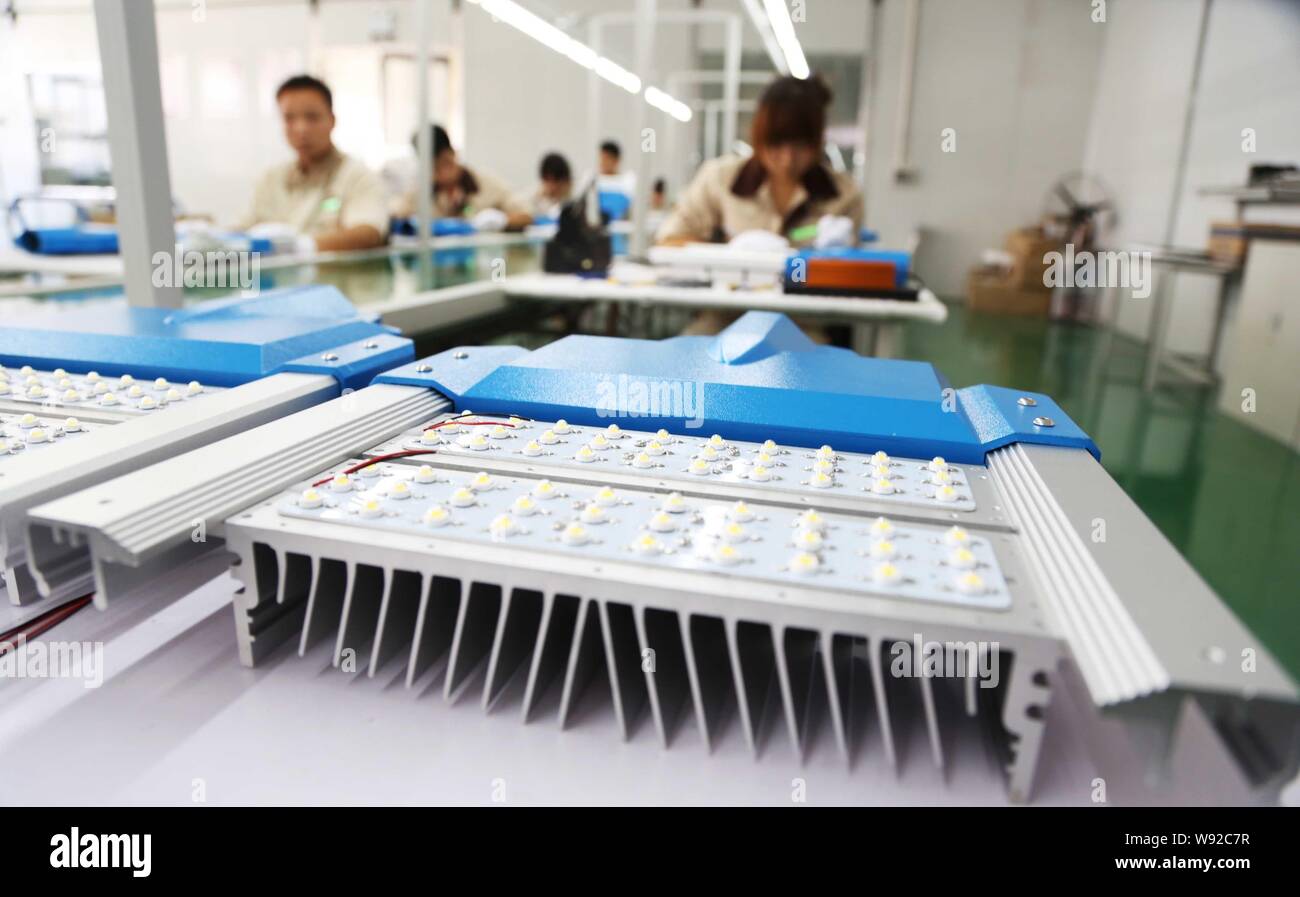 Lavoratori cinesi di fabbricazione di prodotti di illuminazione a una società tecnologica in Xuchang, porcellane centrale provincia di Henan, 28 giugno 2013. Chinas il prodotto interno lordo Foto Stock