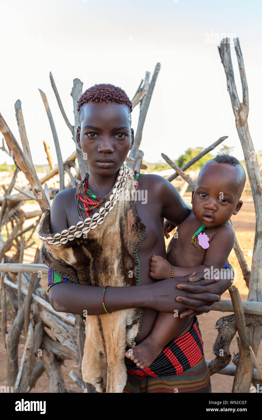 Turmi, Omo River Valley, Etiopia - 10 Maggio 2019: Ritratto di Hamar giovane donna nel villaggio. Gli Hamer sono una tribù primitiva e le donne hanno molti Foto Stock