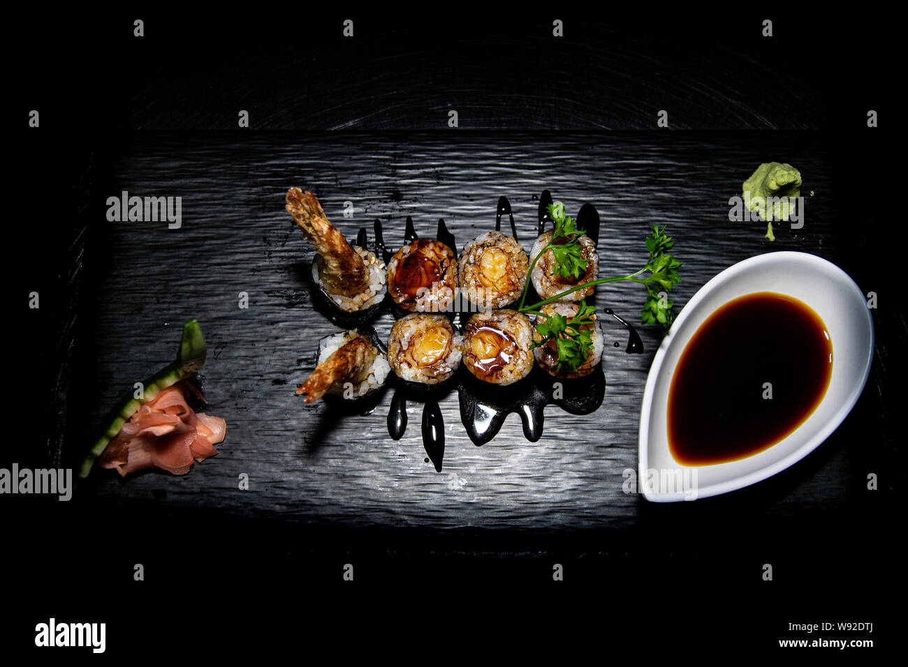 Una gustosa otto pezzi tempura hosomaki rotoli spruzzata con salsa teriyaki Foto Stock