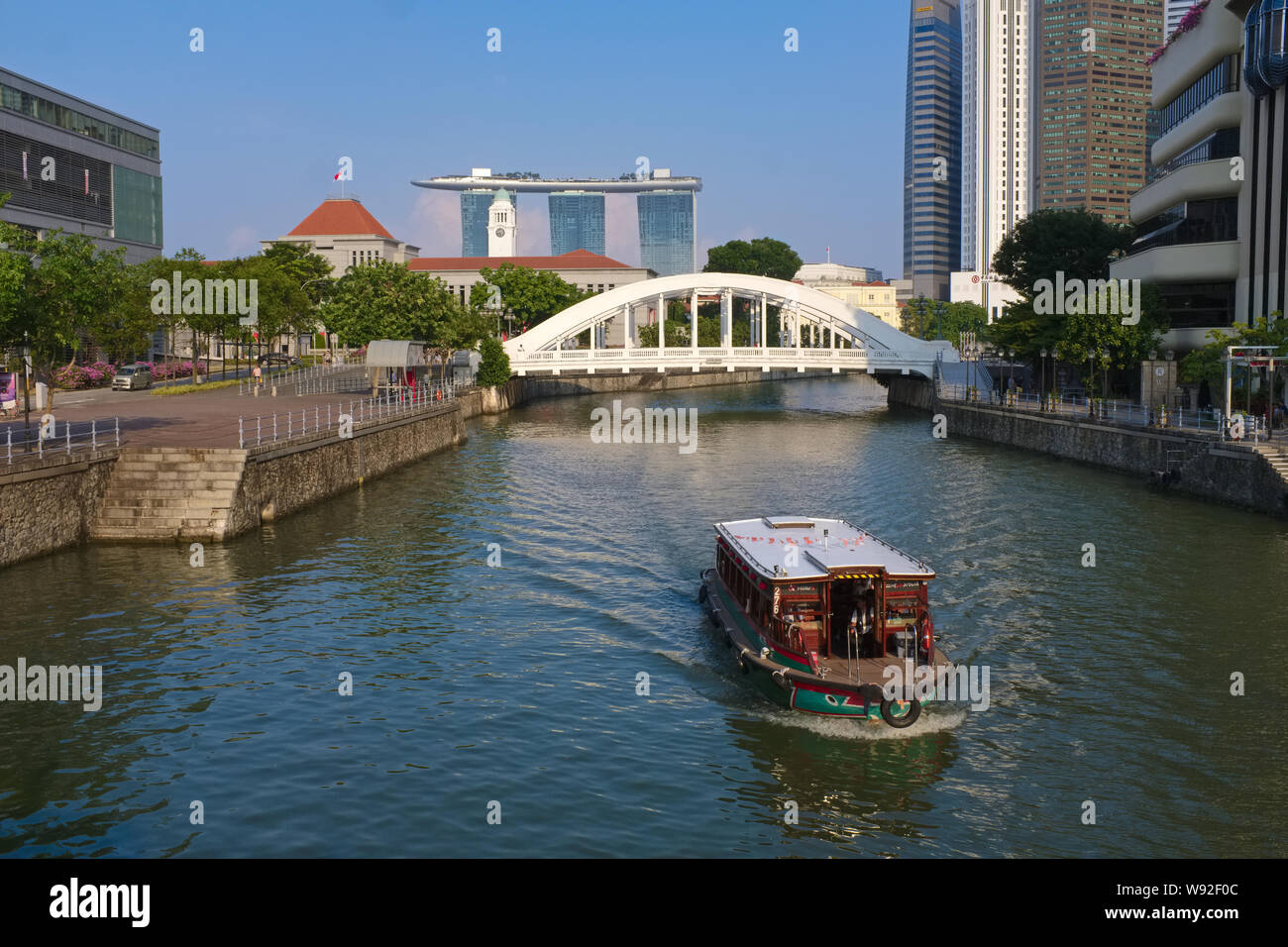 Un'escursione in barca sul Fiume Singapore vicino a Clarke Quay Singapore, Elgin Bridge, il Victoria Theatre & Concert Hall e il Marina Bay Sands Hotel in b/g Foto Stock