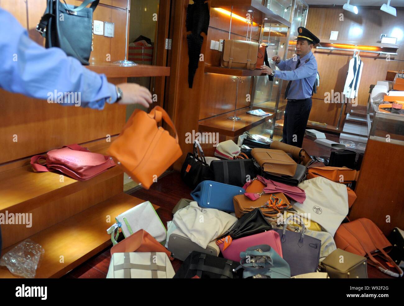 La legge cinese i funzionari di polizia confiscare fake brand di lusso borsette in un negozio a Pechino, in Cina, il 13 maggio 2013. La polizia di Pechino e di applicazione della legge Foto Stock