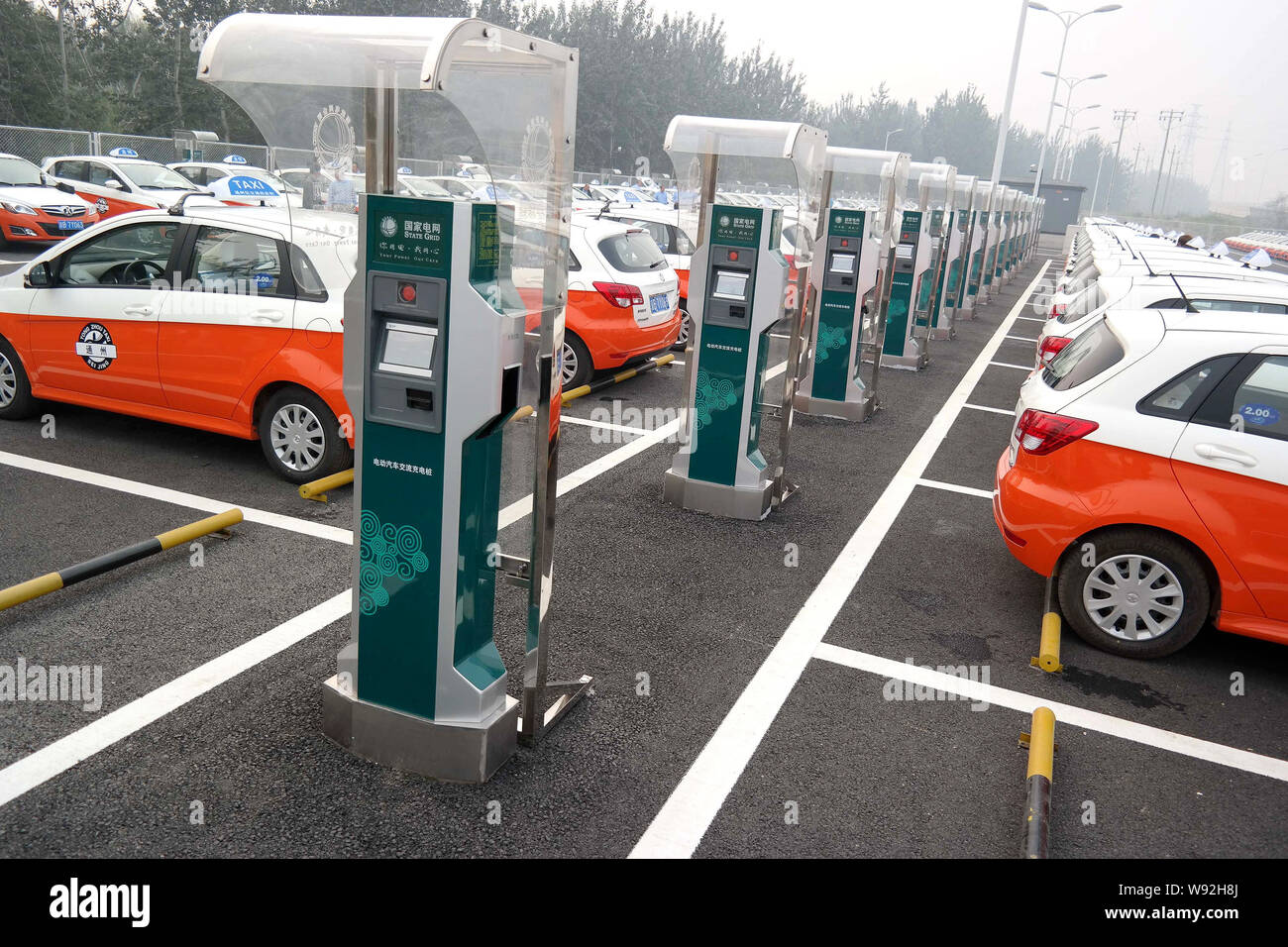 Taxi elettrico sono parcheggiate in corrispondenza di una stazione di carica nel Distretto di Tongzhou, Pechino, Cina, 29 settembre 2013. Pechino dovrebbe avere più di 1.000 Foto Stock