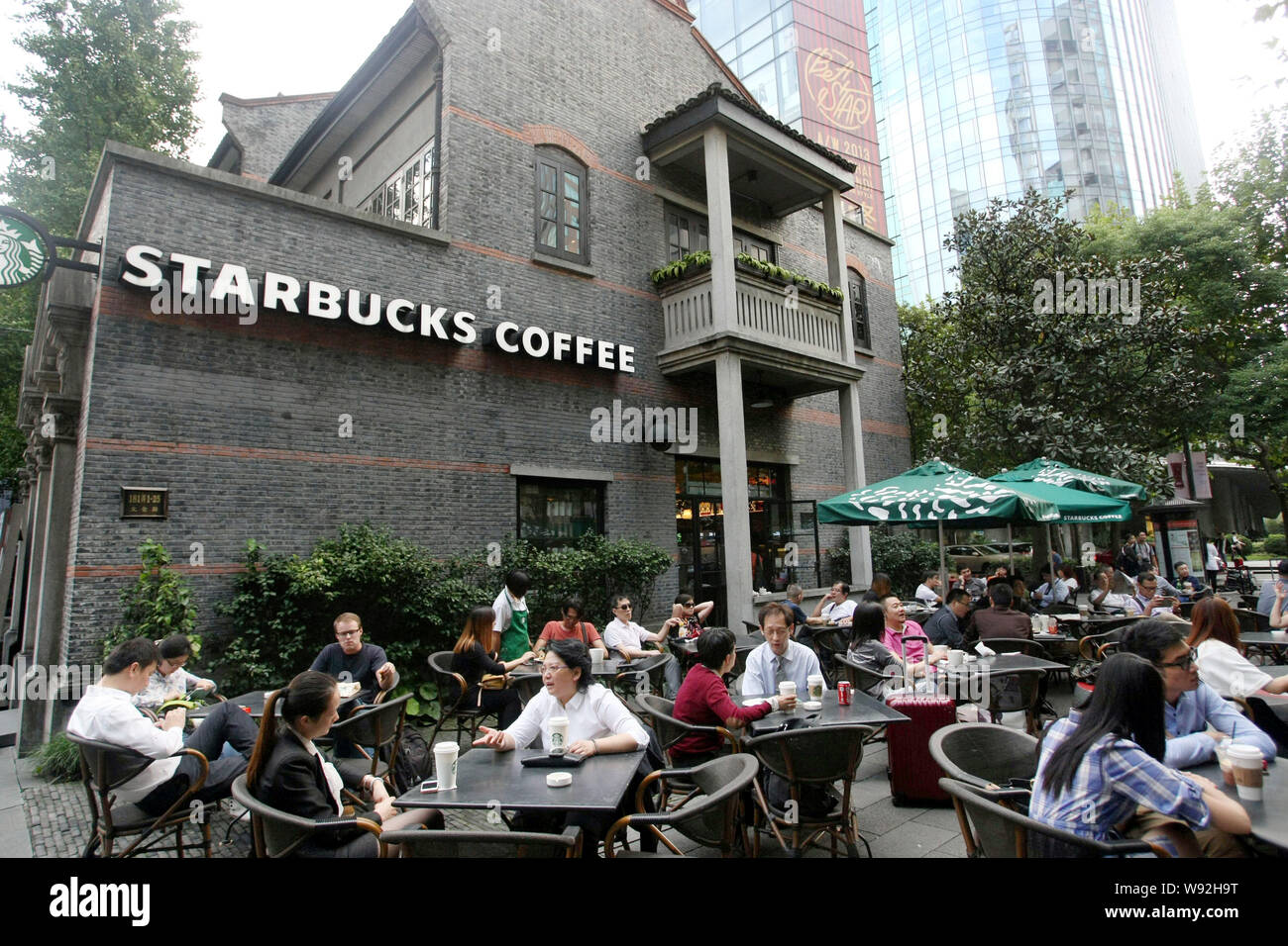 I clienti a bere un caffè in un bar di caffè Starbucks in Cina a Shanghai, 9 ottobre 2013. Noi della catena di caffè Starbucks Corp. vide margine operativo Foto Stock