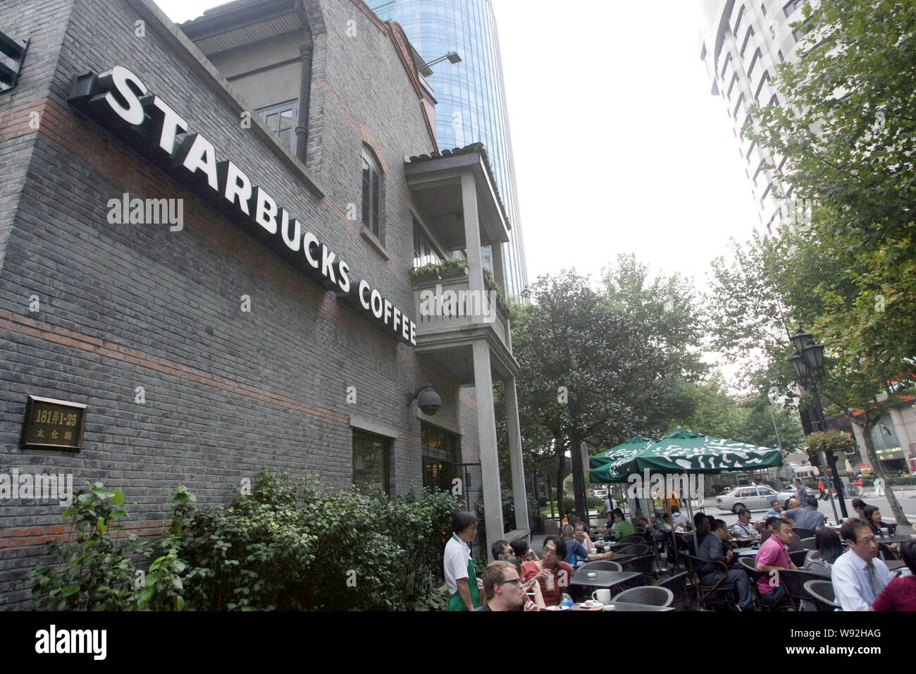 I clienti a bere un caffè in un bar di caffè Starbucks in Cina a Shanghai, 9 ottobre 2013. Noi della catena di caffè Starbucks Corp. vide margine operativo Foto Stock