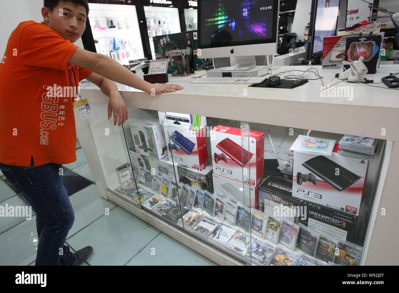 Un venditore pone al bancone dove Sony PS3 console di gioco sono in vendita in un prodotti digitali mall in Cina a Shanghai, 10 luglio 2013. La Cina è expe Foto Stock