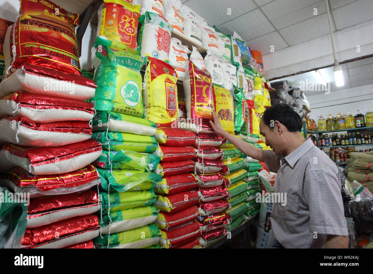 --FILE--un cinese cliente acquista il riso in un supermercato a Shanghai in Cina, il 21 maggio 2013. Un decennio lungo il braccio in porcellane la produzione del riso è probabile che com Foto Stock