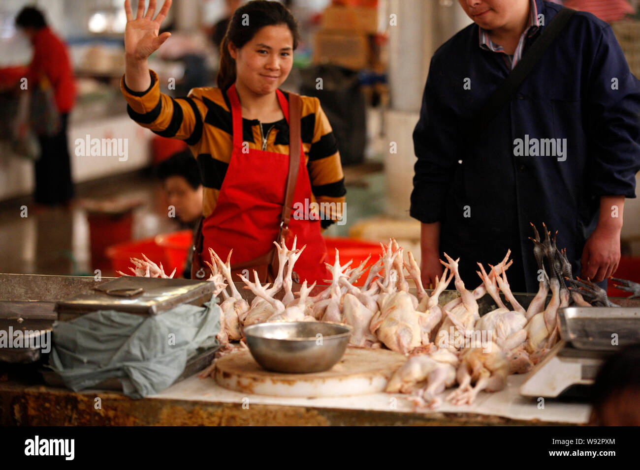 Un pollo cinese venditore gesti al suo stallo a un libero mercato in città Huaibei, est Chinas provincia di Anhui, 16 aprile 2013. Porcellane industria di pollame Foto Stock