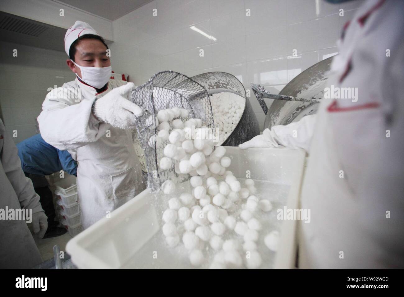 Lavoratori cinesi fanno riso glutinoso gnocchi di patate, noto anche come Yuanxiao, Yuan Xiao o codolo Yuan, presso un negozio prima della prossima festa delle lanterne, anche Foto Stock