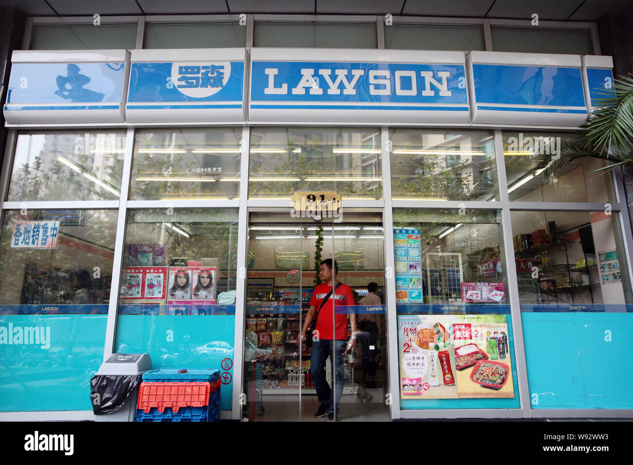 --FILE--un cliente lascia un Lawson convenience store in Cina a Shanghai, 18 settembre 2012. Lawson, il giapponese convenience store catena, rallenta Foto Stock