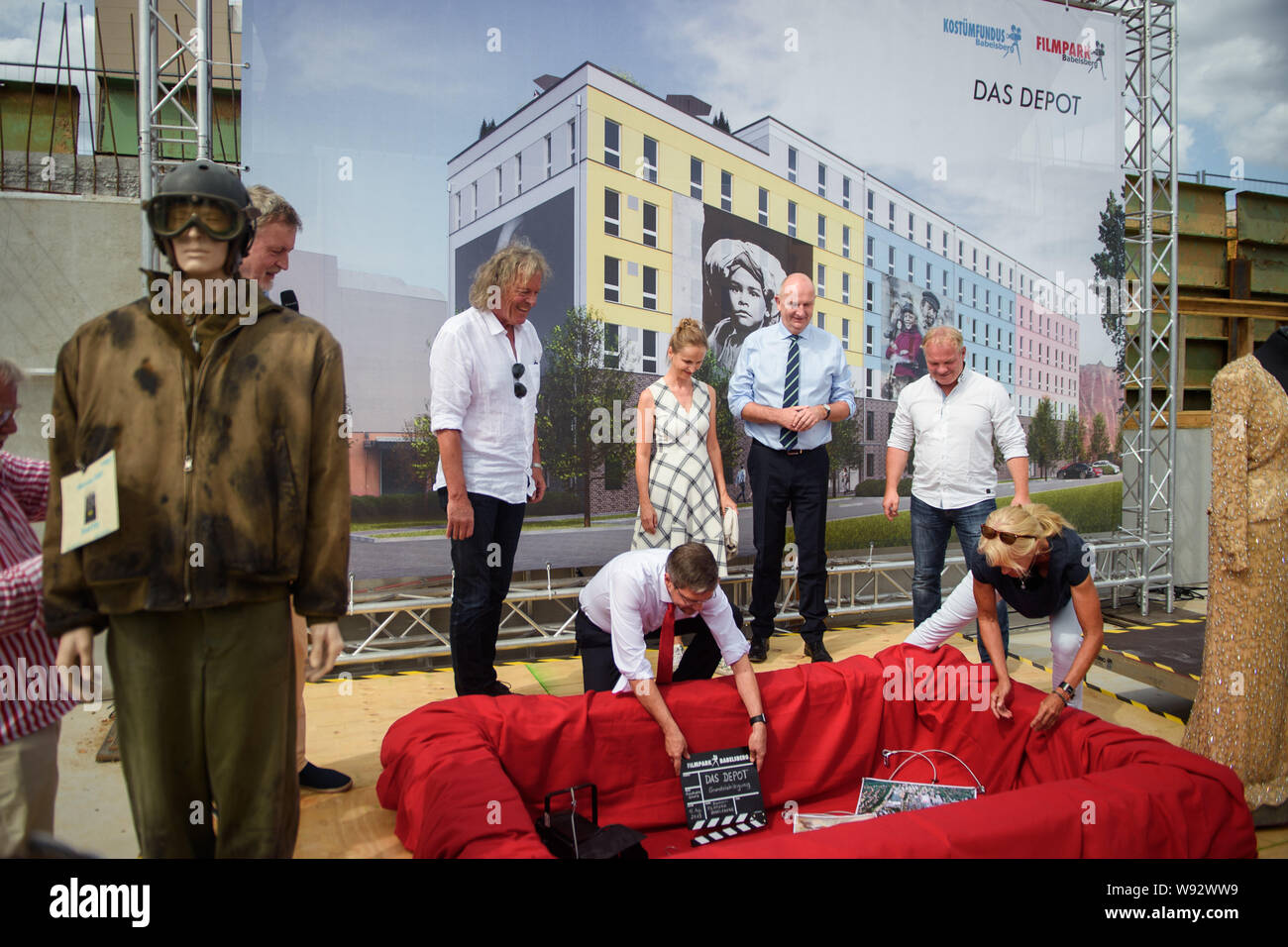 12 agosto 2019, Brandeburgo, Potsdam: Friedhelm Schatz (l-r), Managing Director di il Filmpark Babelsberg, Mike Schubert (SPD), Sindaco di Potsdam, Gabriele Leuter, Direttore del Costume Studio Babelsberg, Dietmar Woidke (SPD), il primo ministro del Land di Brandeburgo, Jan Kretzschmar, managing partner di KW-Development GmbH, e Ute Kanter, guardaroba master in costume fundus Babelsberg, mettere alcuni cimeli dell'il Filmpark in una capsula del tempo sul sito in costruzione durante un evento di porre la prima pietra per il nuovo costume fundus nel il Filmpark Babelsberg. Foto: Gregor Fischer/dpa/ZB Foto Stock