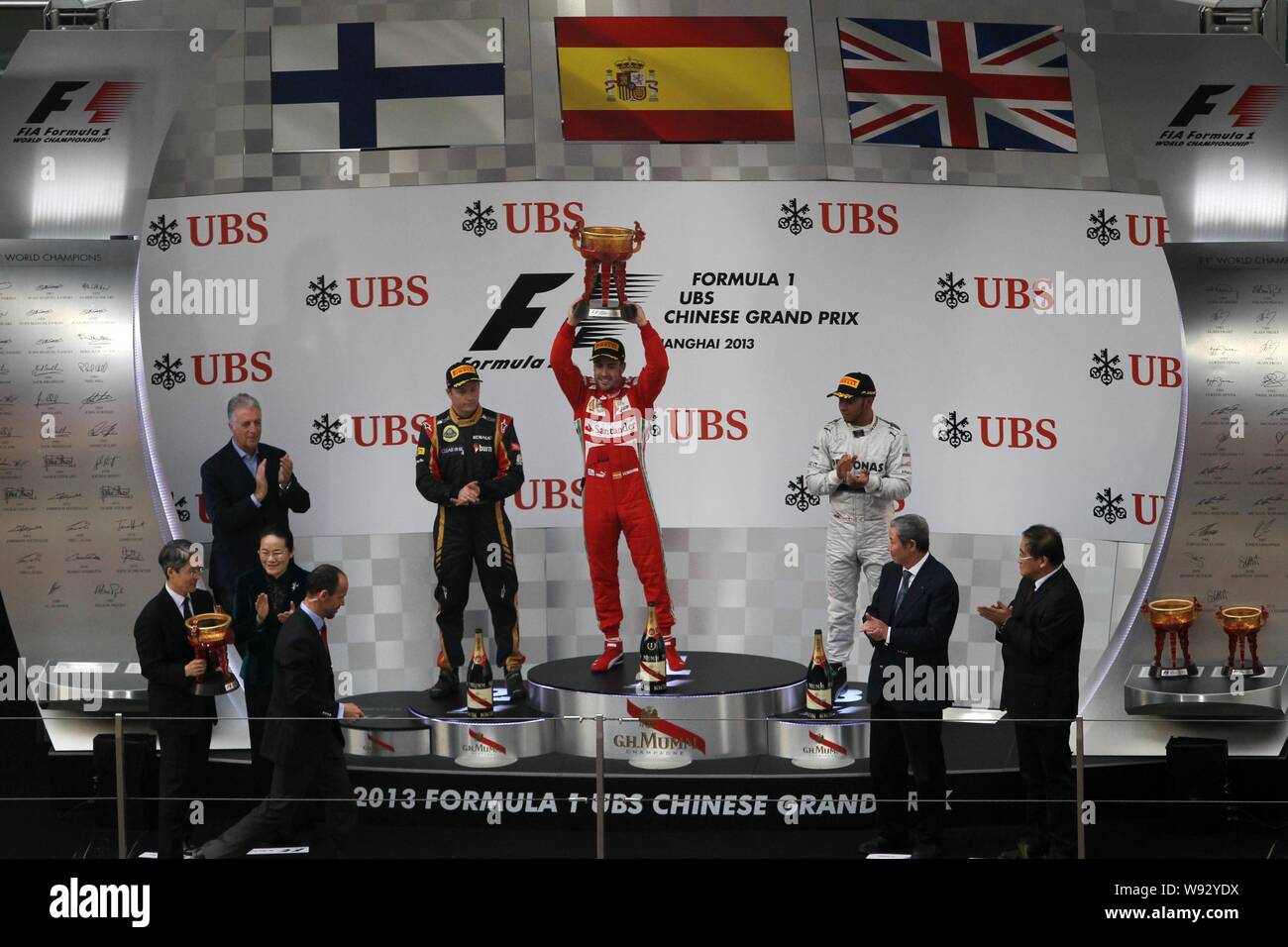 Spagnolo di F1 driver Fernando Alonso della Ferrari, centro trattiene il suo campione del trofeo accanto al finlandese di F1 driver Kimi Raikkonen di Lotus, sinistra e Britis Foto Stock