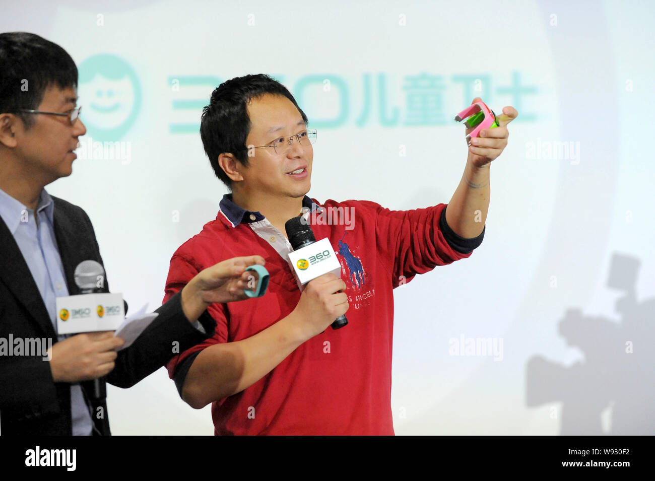 Zhou Hongyi, destra, Presidente e CEO di Qihoo 360 Technology Co., Ltd., rende una introduzione di 360 bambini Guard smart guarda ad una pressa conferiscono Foto Stock