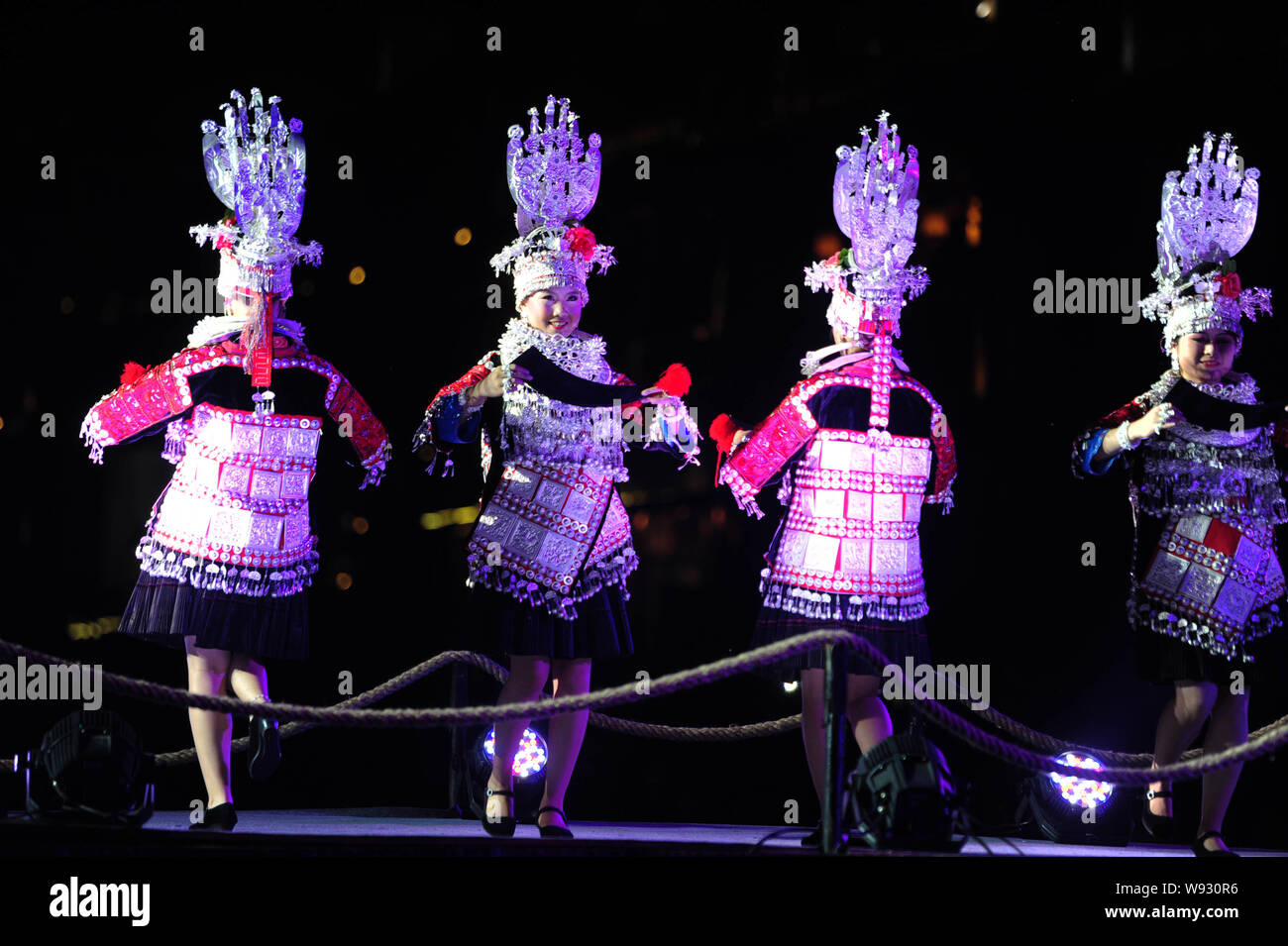 Le donne cinesi di Miao minoranza etnica vestite nei tradizionali costumi Miao eseguire alla cerimonia di chiusura di un festival culturale su Miao ornam argento Foto Stock