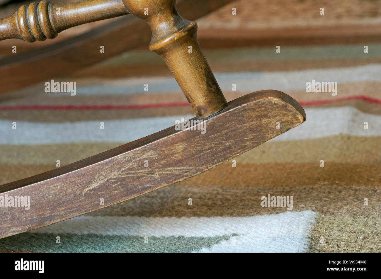 Sezione bassa di una sedia a dondolo su un tappeto Foto Stock