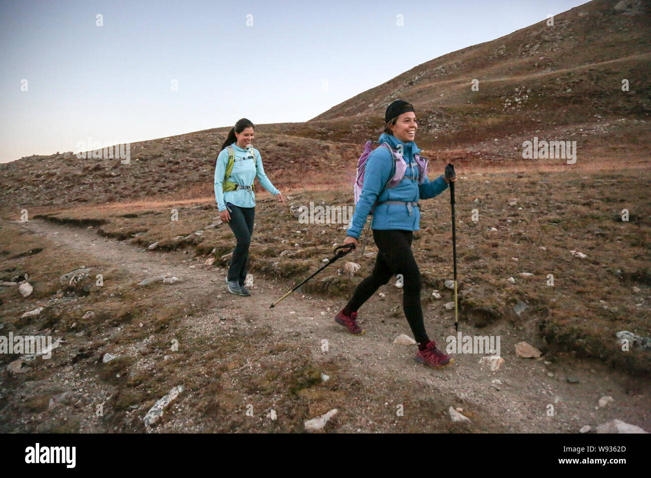 Due giovani donne traccia corridori godere di singola traccia il sentiero delle Montagne Rocciose Foto Stock