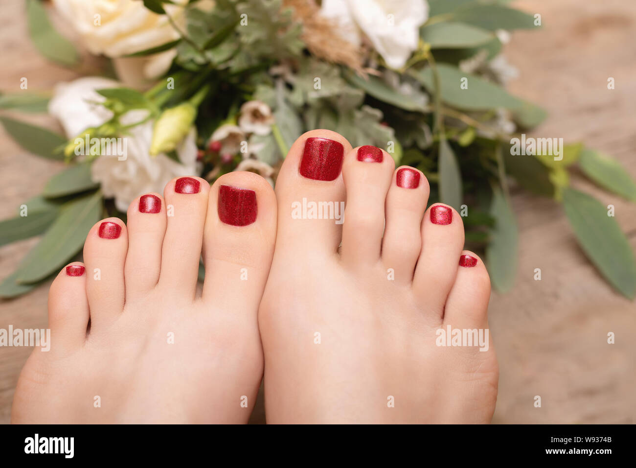 Belli i piedi femminili con red glitter pedicure. Foto Stock