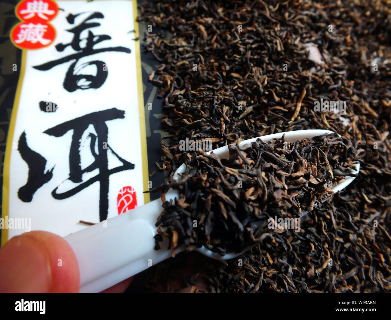 --FILE--un cliente seleziona Pu-erh tè presso un negozio in Yichang, porcellane centrale provincia di Hubei, 17 giugno 2013. Prezzi di Pu-erh, un tipo di scuro fermentato Foto Stock