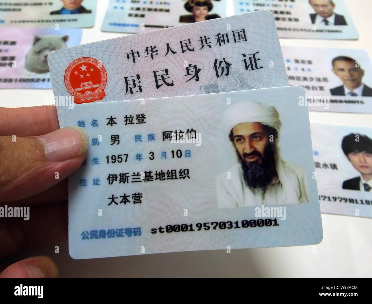Un uomo mostra un fake cinese scheda ID dell ex leader di Al Qaeda Osama bin Laden in vendita in una fase di stallo su di una strada nella città di Guangzhou, sud Chinas Guangdong Foto Stock