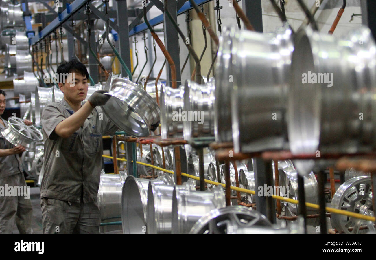 FILE--lavoratori cinesi esaminare i cerchioni auto sulla linea di produzione  in un impianto di Sanmenxia ruota Dicastal Manufacturing Co., Ltd. in città  Sanmenxia, cento Foto stock - Alamy