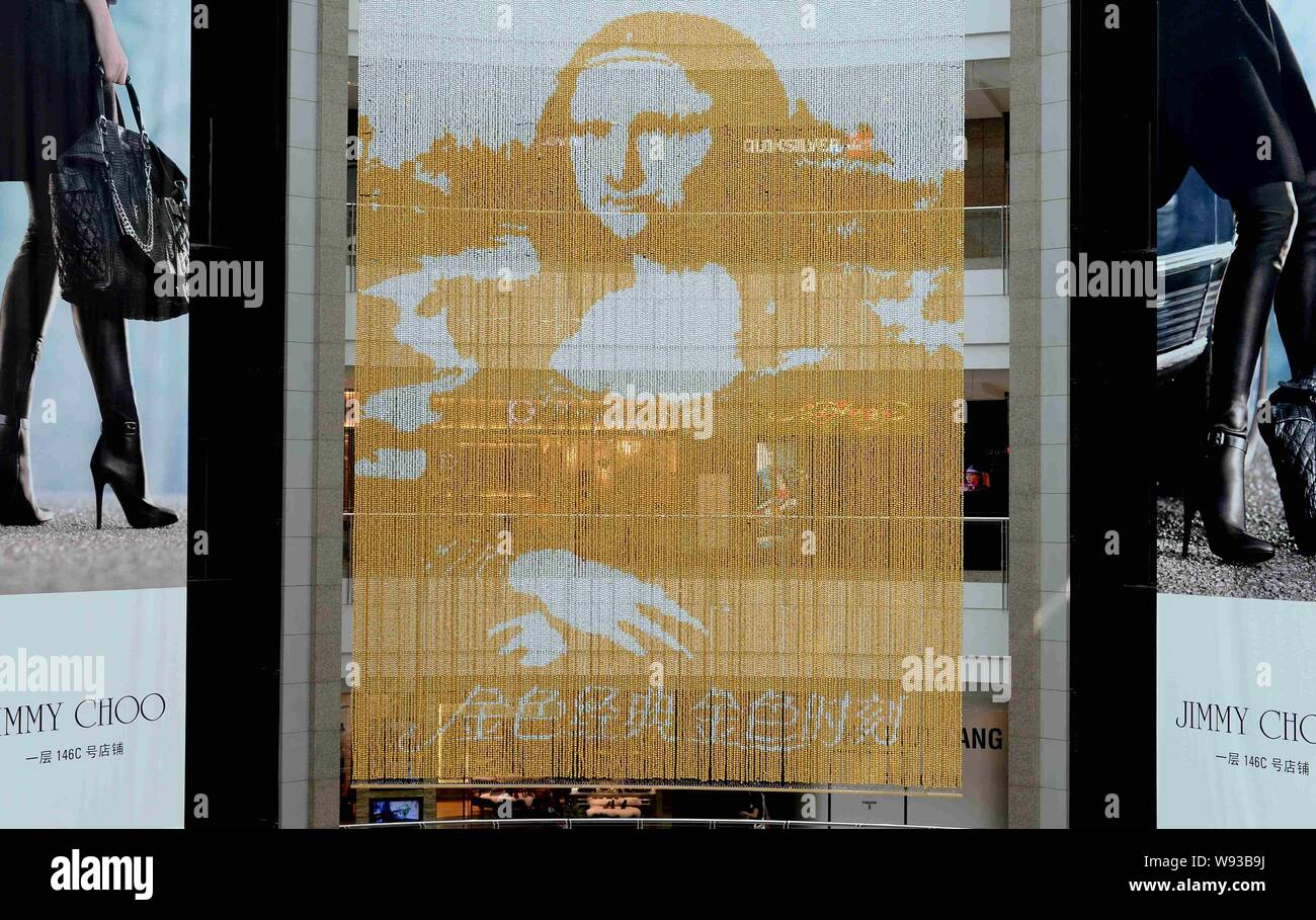 Un golden ritratto di Mona Lisa composta di più di 100.000 Ferrero Rocher sfere di cioccolato è appeso al Grand Gateway shopping mall a Shanghai in Cina, Foto Stock