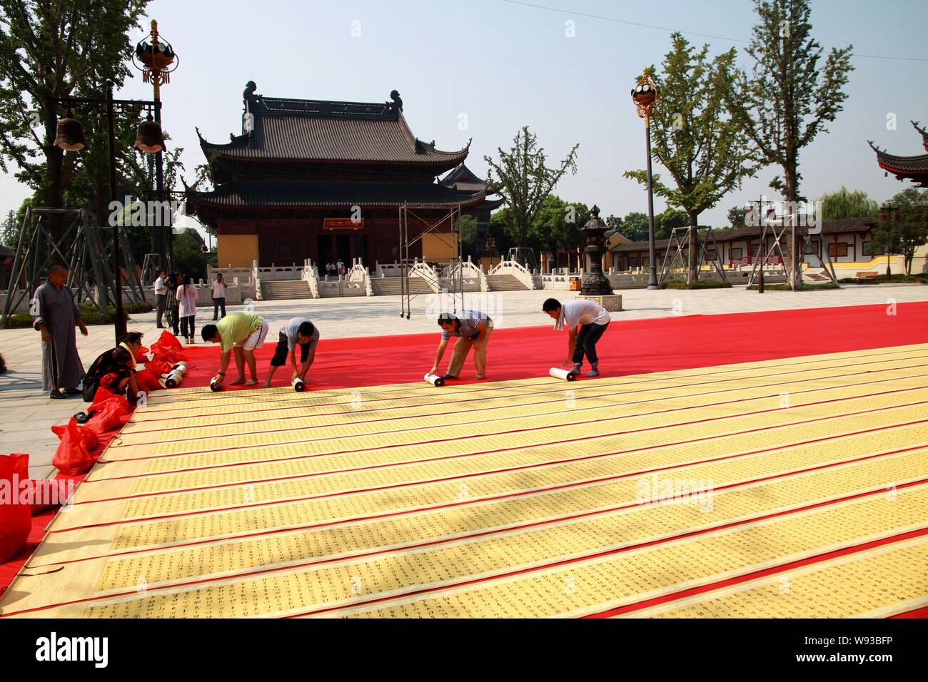 I dipendenti del Record del Mondo di associazione scorre il dispiegamento della calligrafia denominato Lotus Sutra creato da voi Zhaojing per confermare la sua lunghezza a Te Zhongyuan Foto Stock