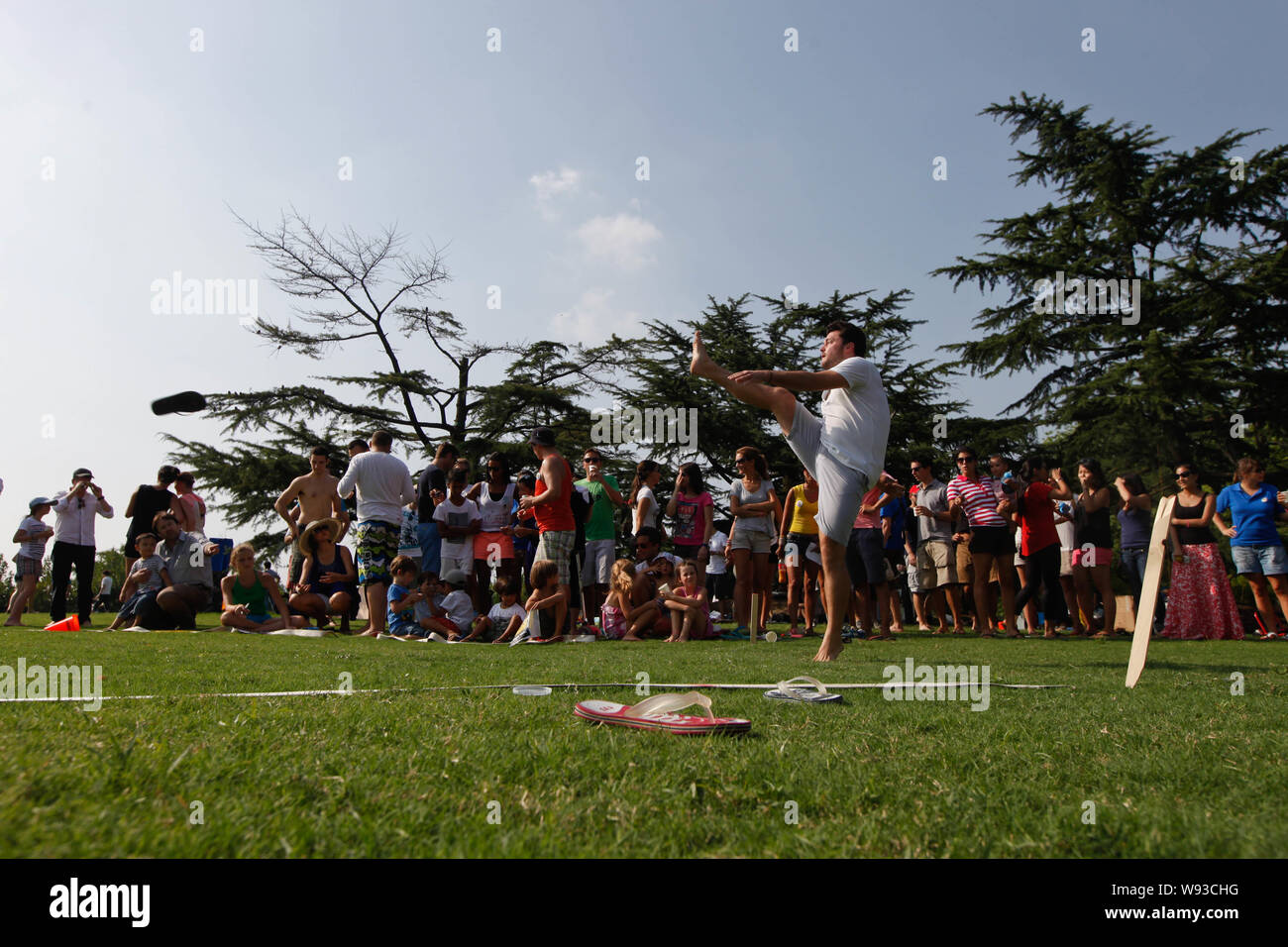 Un nuovo concorrente estera calci un flip-flop durante la quarta buttare Tatane Cup presso il Century Park a Pudong, Shanghai, Cina, 15 settembre 2013. Il 4 passi Foto Stock