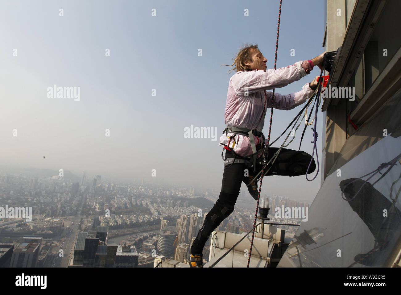 Il francese Spiderman Alain Robert è scalare il 288-metro-alto orizzonte Shimao edificio centrale nella città di Shaoxing, est Chinas nella provincia di Zhejiang, 21 Decemb Foto Stock
