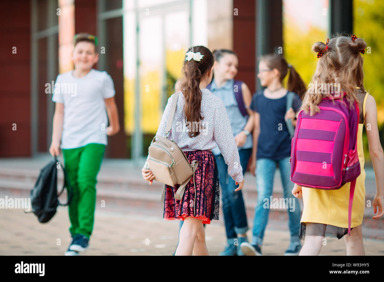 Compagni di scuola andare a scuola. Gli studenti salutarci. Foto Stock