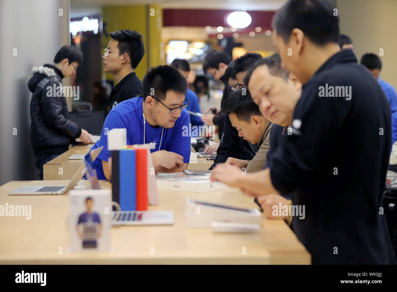 I dipendenti cinesi assistere i clienti a comprare un iPad aria tablet PC presso un negozio Apple Store in Cina, 1 novembre 2013. Apple Inc. ha lanciato il suo nuovo iPad Foto Stock