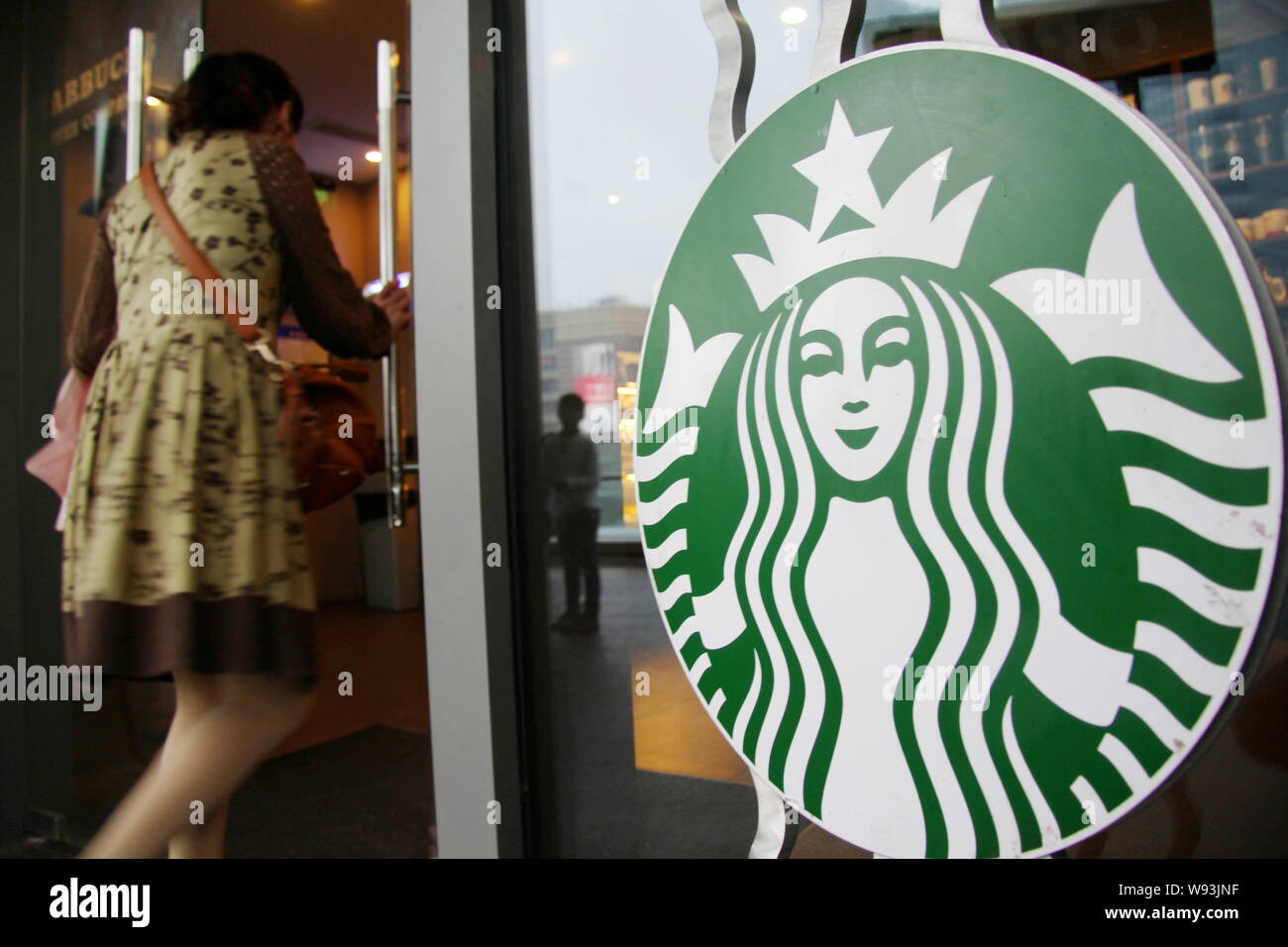 Un cliente cinese passeggiate in un bar di caffè Starbucks in Cina a Shanghai, 7 ottobre 2013. I prezzi elevati per il caffè Starbucks in Cina ha condotto t Foto Stock