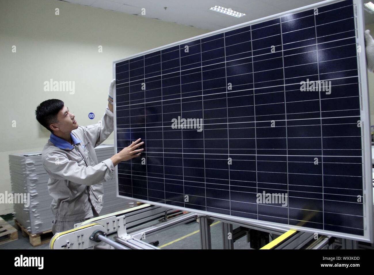 --FILE--un lavoratore cinese esamina un pannello solare per essere esportato a un impianto in Lianyungang, est Chinas provincia dello Jiangsu, 29 luglio 2013. Cina dominano Foto Stock