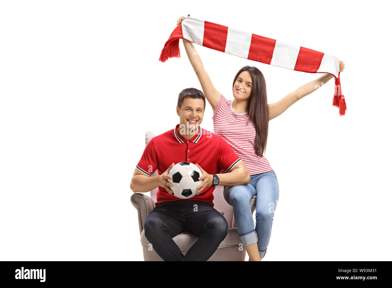 Giovane maschio e femmina gli appassionati di calcio con un campo di calcio e un foulard seduto in poltrona isolati su sfondo bianco Foto Stock