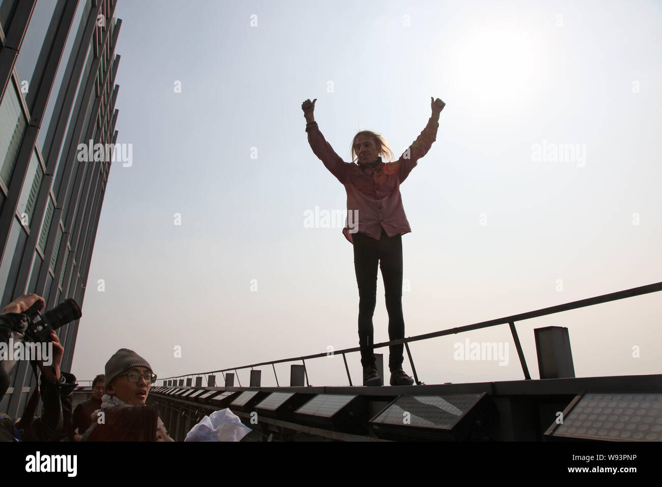 Il francese Spiderman Alain Robert celebra dopo aver terminato la scalata di 288-metro-alto orizzonte Shimao edificio centrale nella città di Shaoxing, est Chinas Zhej Foto Stock