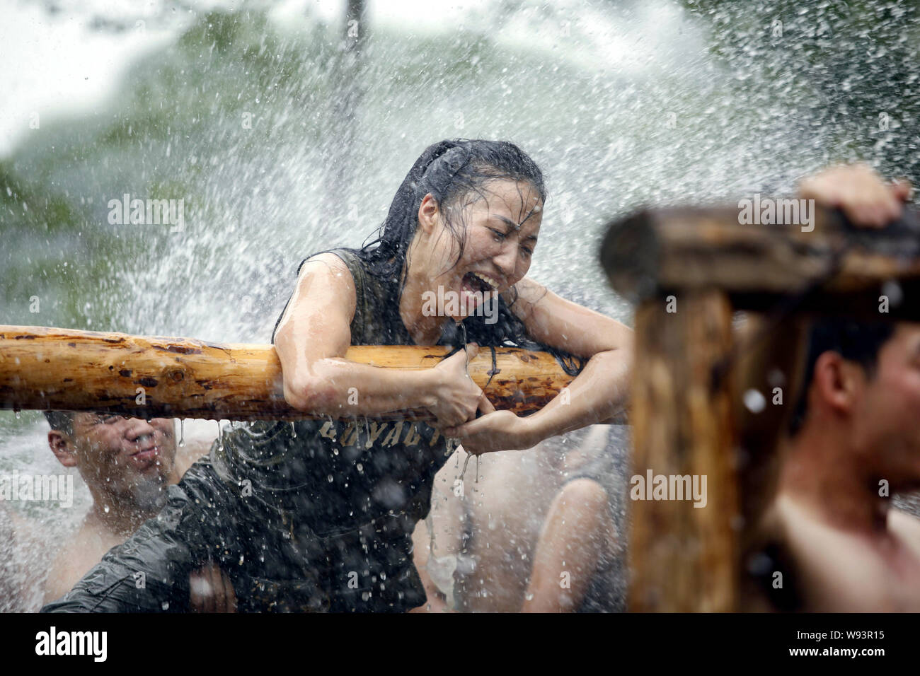--FILE--A FEMMINA partecipante urla e lei tenta di scavalcare un ostacolo in schizzi di acqua durante una guardia del corpo programma di formazione al boot camp di Ge Foto Stock