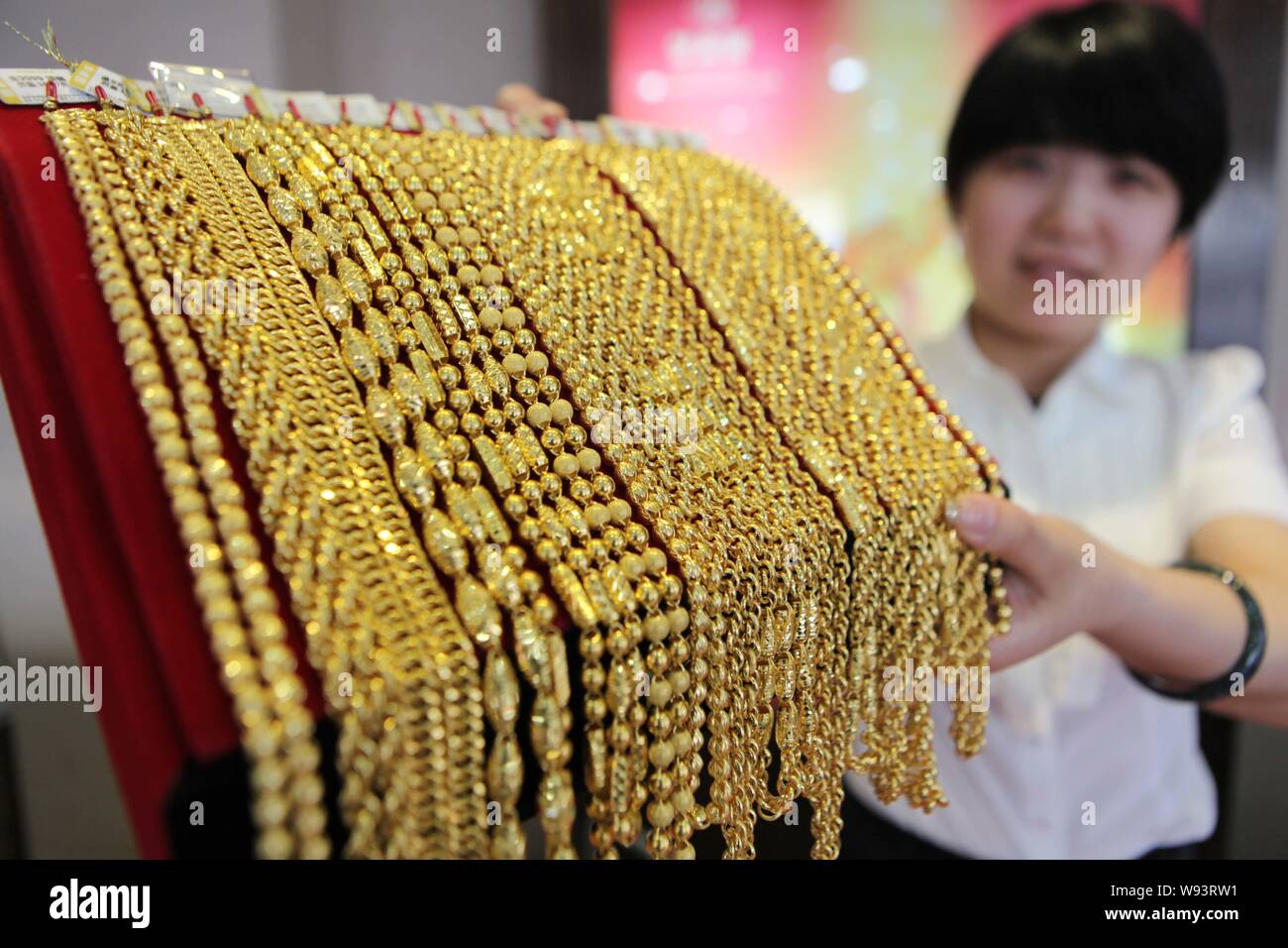 Un addetto cinese mostra collane d'oro presso un negozio di oro in Ganyu County, est Chinas provincia dello Jiangsu, 20 giugno 2013. L'oro è sceso al di sotto di $1.200 venerdì (2 Foto Stock