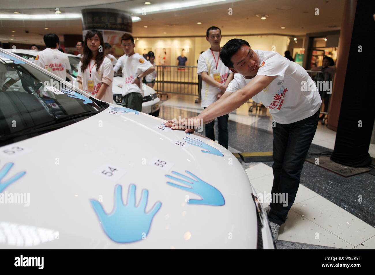 Concorrenti cinesi tenere le mani sulla Volkswagen Polo GTI auto durante una mano-su-auto competizione endurance a Super Brand Mall in Lujiazui Financ Foto Stock