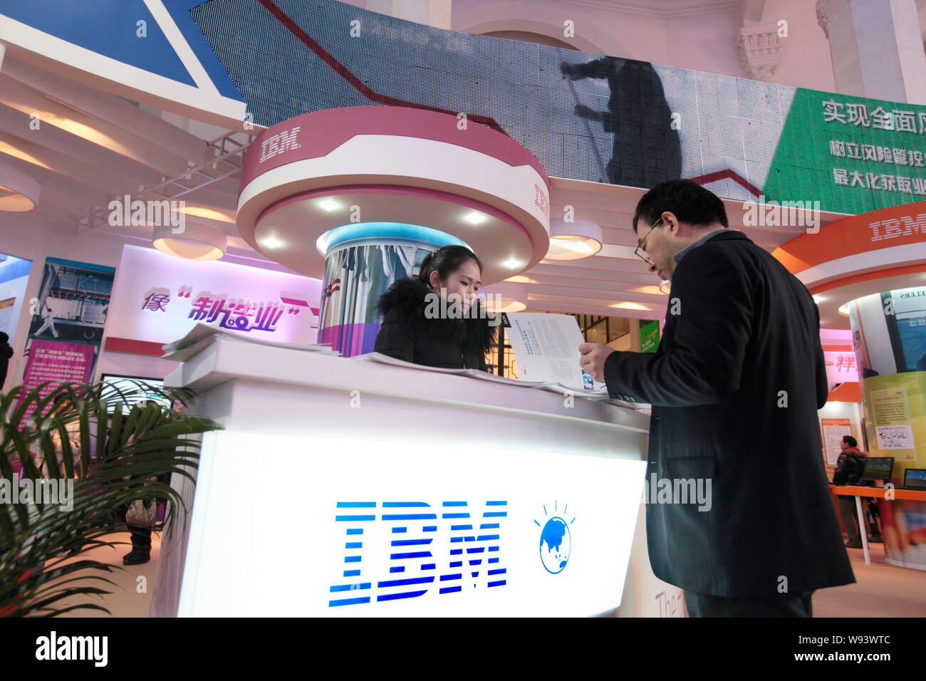 --FILE--un visitatore sorge nella parte anteriore del piedistallo di IBM in occasione di una mostra a Pechino, in Cina, il 22 dicembre 2012. Chinas Ministero della Pubblica Sicurezza un Foto Stock