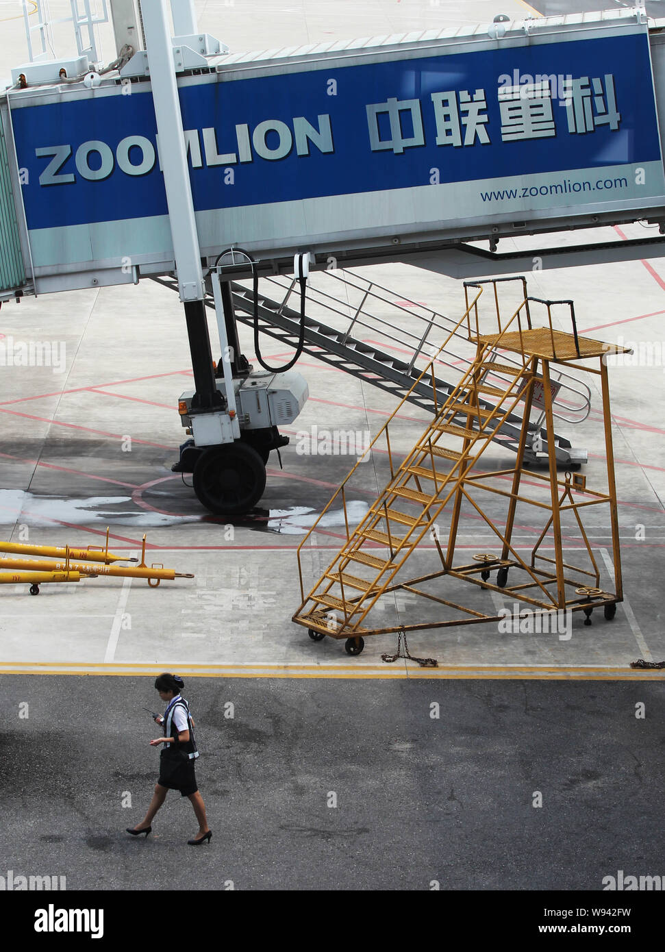 --FILE--un dipendente passeggiate passato un annuncio di Zoomlion a Changsha Huanghua International Airport in Changsha, porcellane centrale nella provincia del Hunan, Foto Stock