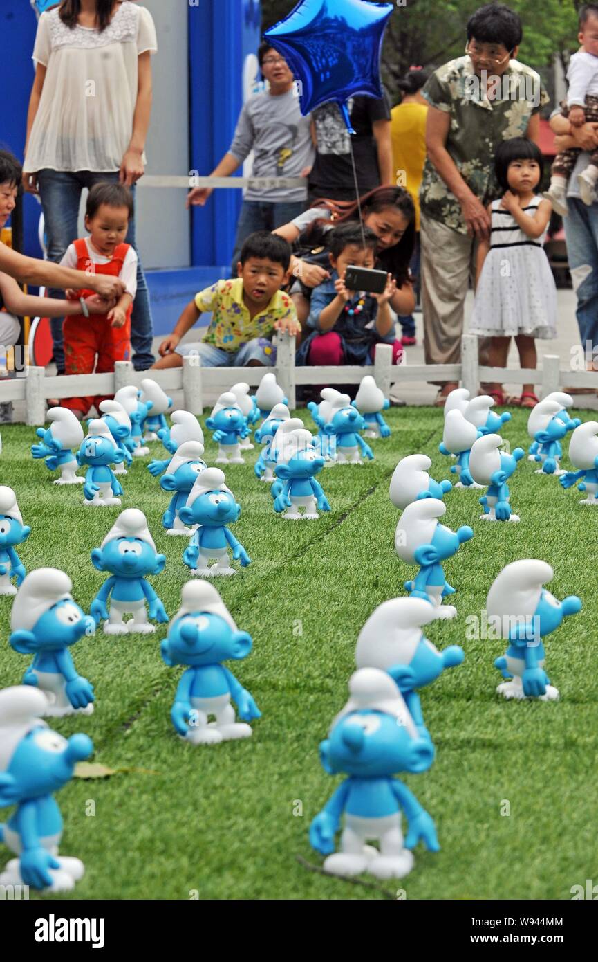 Visitatori guardare le figure dei puffi durante una mostra per celebrare il cinquantacinquesimo anniversario della creazione dei puffi nella città di Wuhan, Chi centrale Foto Stock