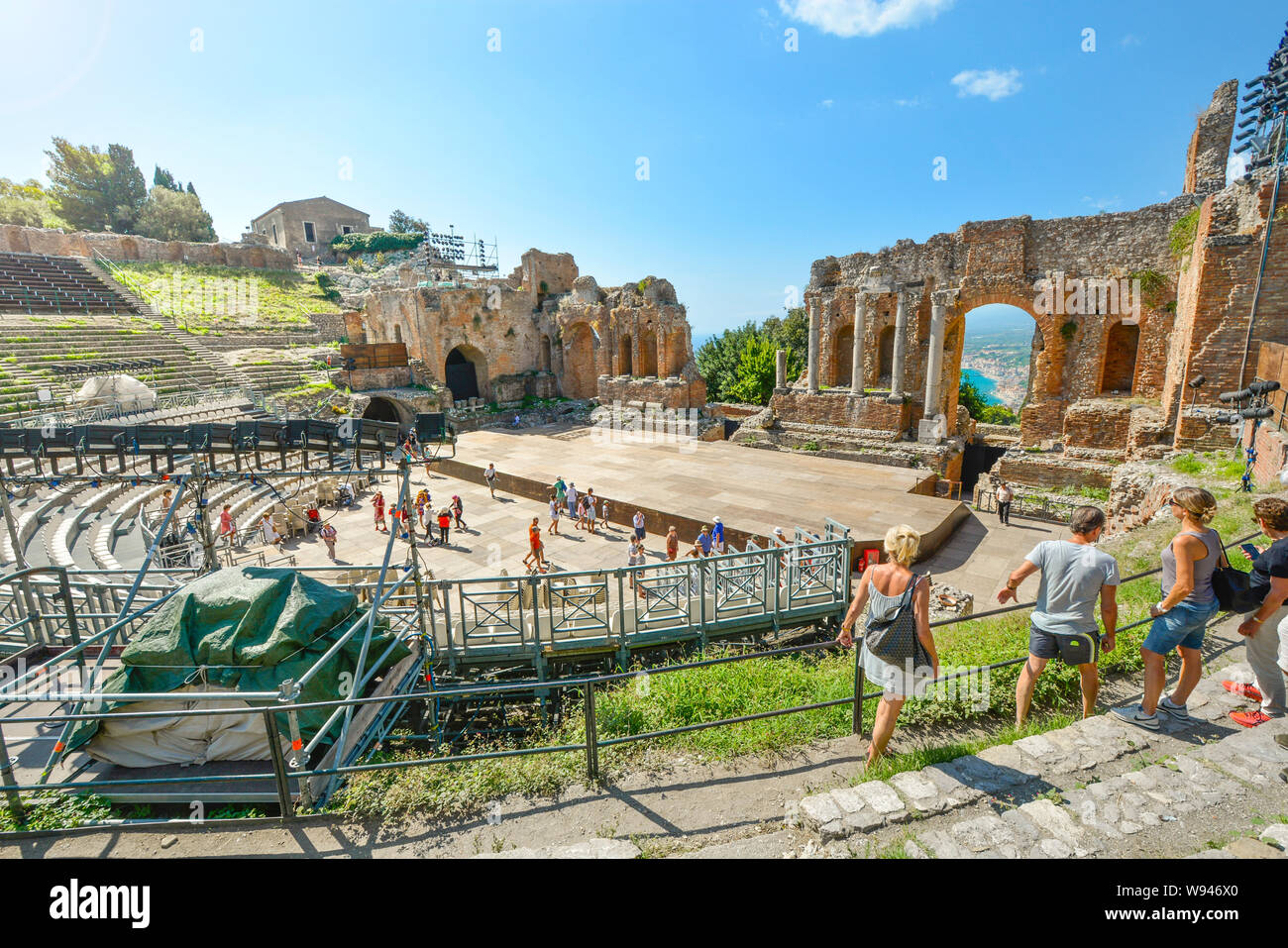 I visitatori a piedi l'antico anfiteatro presso lo storico teatro greco o di Teatro Greco sull'isola siciliana di Taormina, Italia Foto Stock