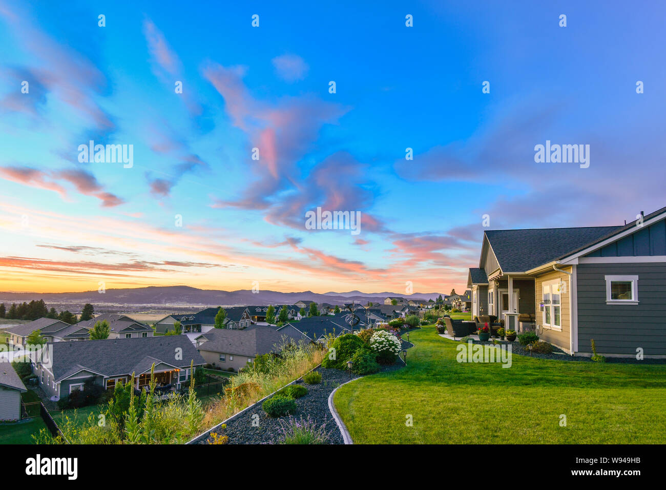 Un bellissimo tramonto colorato di rosa e aqua blu il colore del cielo sopra un tipico american suddivisione sul pendio di una collina in Spokane Washington. Foto Stock