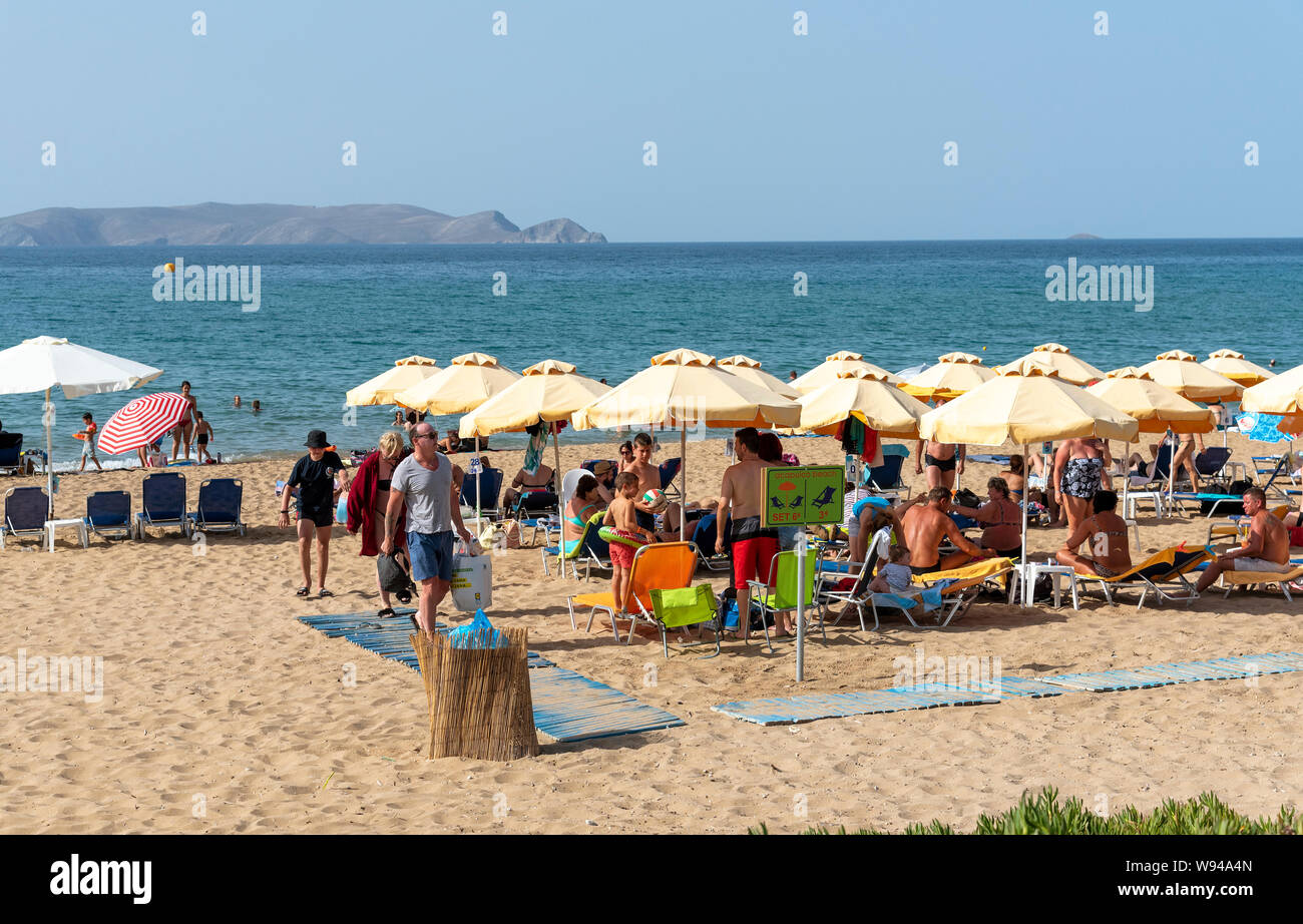 Iraklion, Creta, Grecia. Giugno 2019. Acapulco Beach si trova vicino all'aeroporto Iraklion. I turisti a prendere il sole. Dia isola disabitata in background. Foto Stock