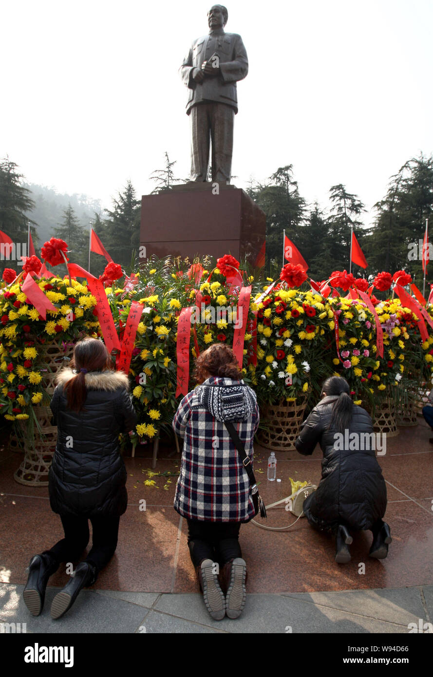 Le donne cinesi si inginocchiano per dimostrare il rispetto di fronte ad una statua di Mao Zedong durante una cerimonia per commemorare il centoventesimo anniversario della nascita di Mao Foto Stock